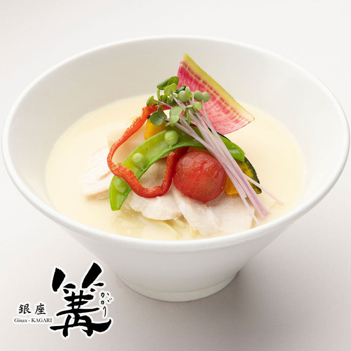 Bowl of Ginza Kagari tori paitan soba, creamy white chicken broth topped with sliced chicken breast, cherry tomato, snap pea and sprouts